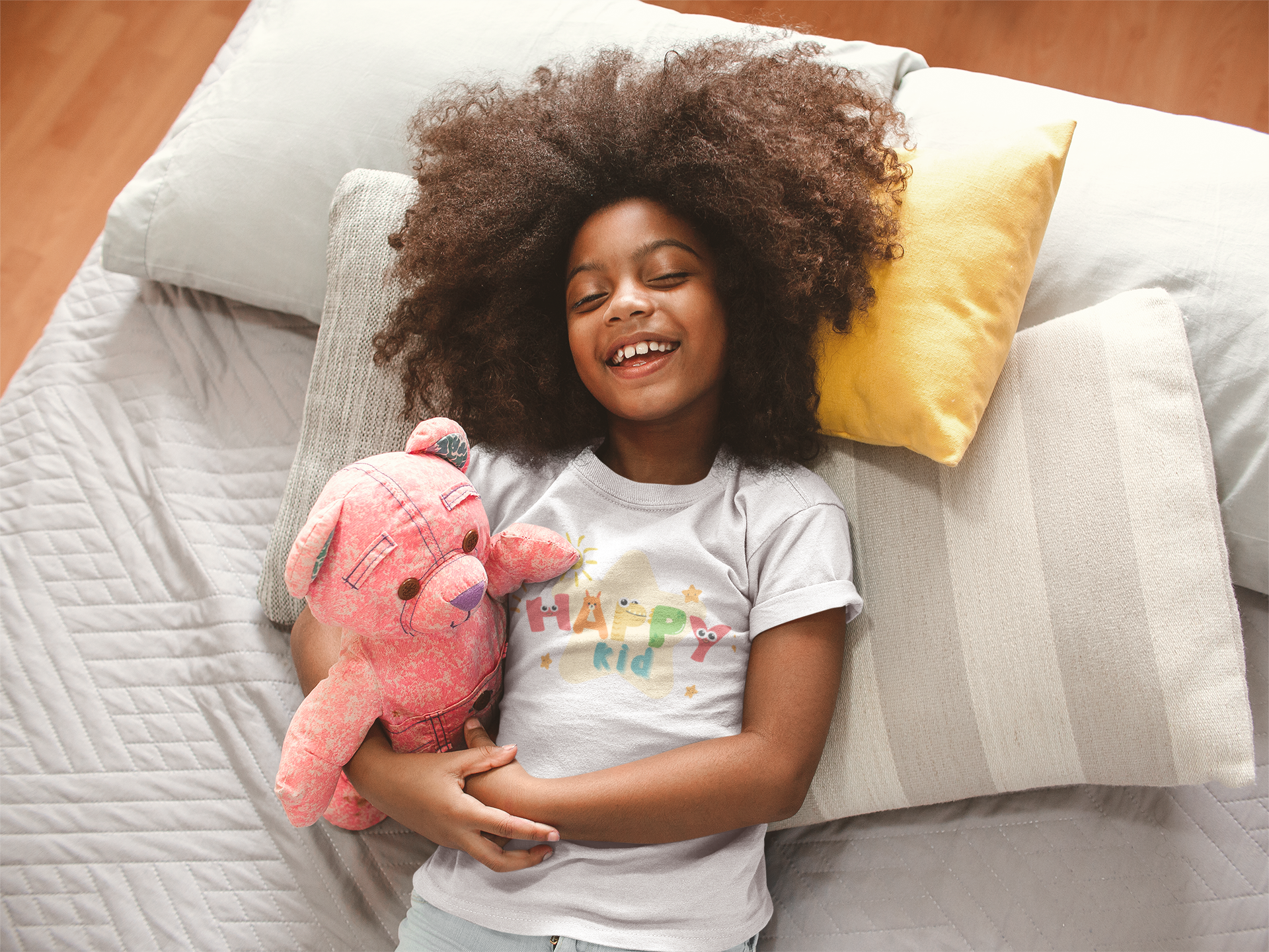 t-shirt-mockup-of-a-smiling-black-girl-with-curly-hair-on-bed-a21319